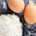 overhead view of pile of flour and two eggs