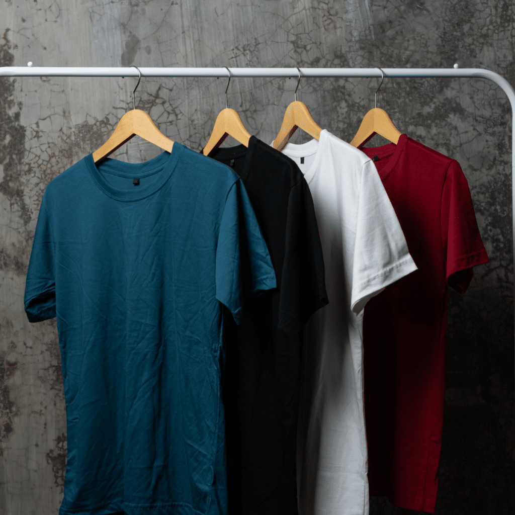 Plain t-shirt of various colors are hung on the clothes rack