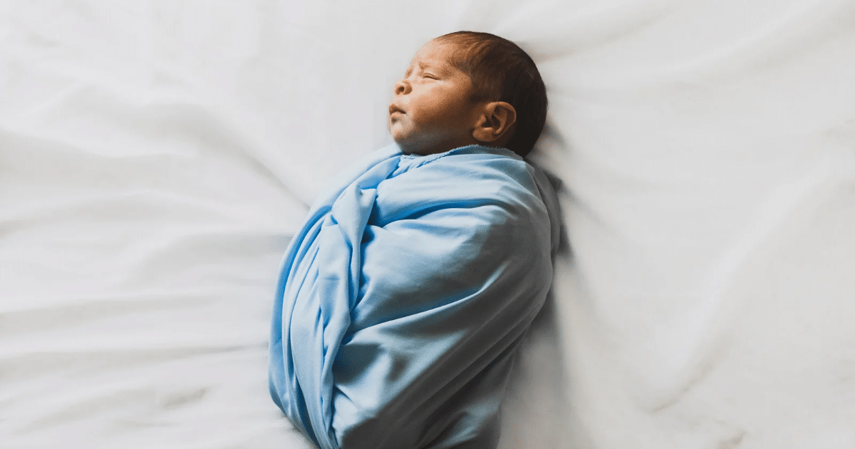 Photo of new boen baby covered with blue blanket