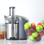 Apple juice on juice machine-juicing concept. Apples in bowl in kitching and fresh pressed juice.