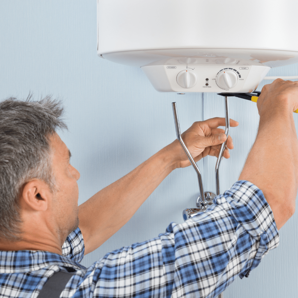 Close up of mid-adult male plumber installing water heater