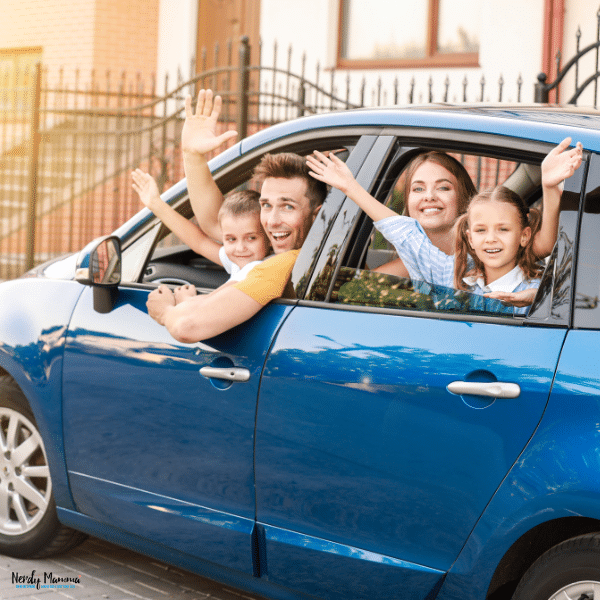 A family of four inside a blue car.