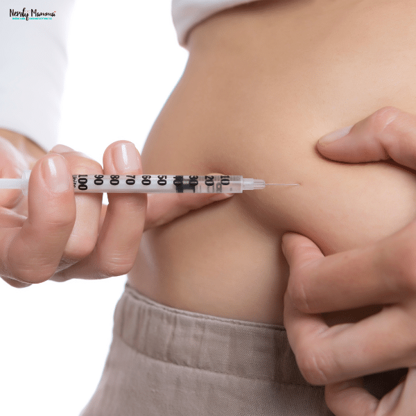 An image of a woman injecting herself on the belly with a syringe.