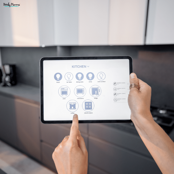 A person holds a tablet with smart home controls displayed for managing kitchen appliances.