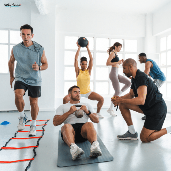 A group of people engaged in an intense indoor fitness training session with a coach assisting one of them.