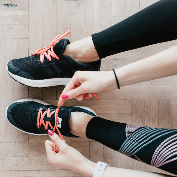 Person tying athletic shoes with bright laces, showing everyday sneakers used by busy moms for comfort and activity.