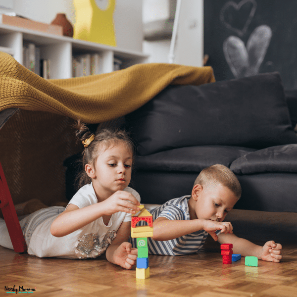 Young children playing with colorful blocks in a cozy living room designed for comfortable and kid-friendly family living.