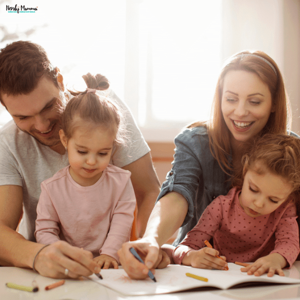Parents and young children working together at a table, representing open communication and collaboration that support successful co-parenting and family decision-making.