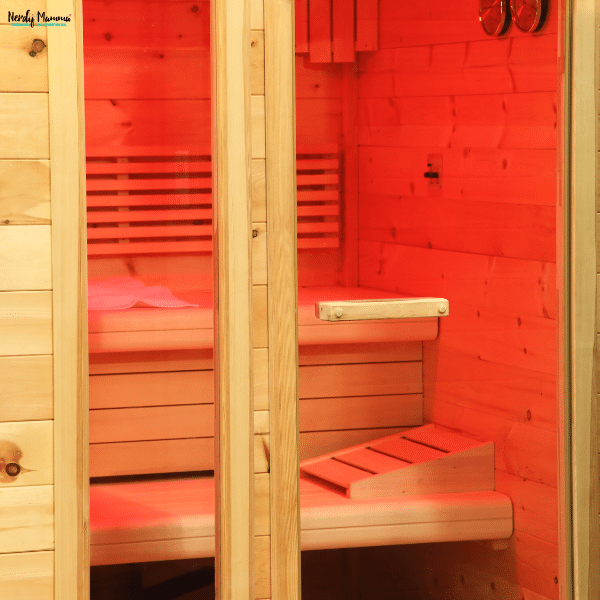 Home infrared sauna cabin with heated wooden seating and red light therapy for wellness and stress relief.