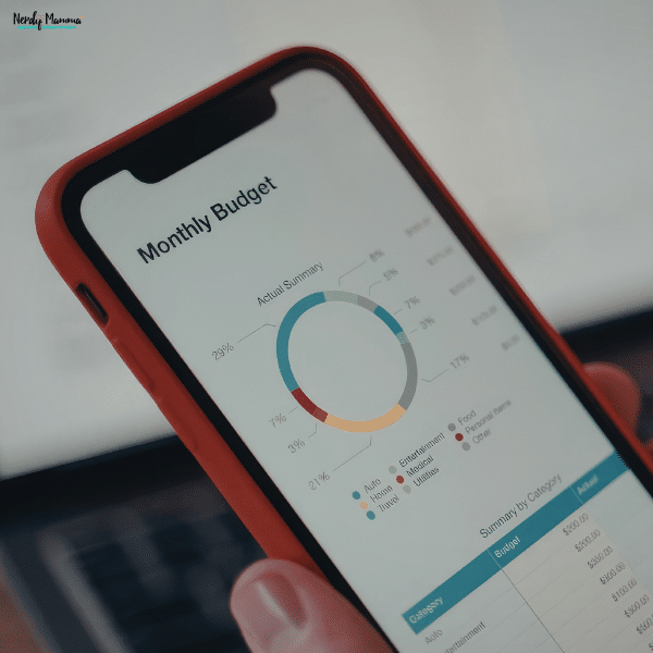 Smartphone displaying a budgeting app with spending categories and financial data to help parents track household expenses.