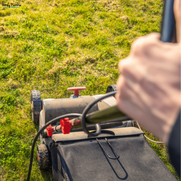 Electric lawn mower trimming a grassy yard, highlighting an eco-friendly approach to lawn care with reduced emissions and energy use.