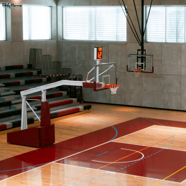 Indoor basketball court with hardwood flooring and regulation hoops, providing a dedicated space for year-round basketball training and skill development.