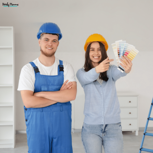 Homeowner reviewing paint color samples with a painting professional while planning an interior home painting project.