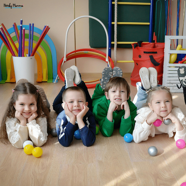 Children playing with colorful toys and activity equipment indoors, representing summer-ready family spaces for active kids.