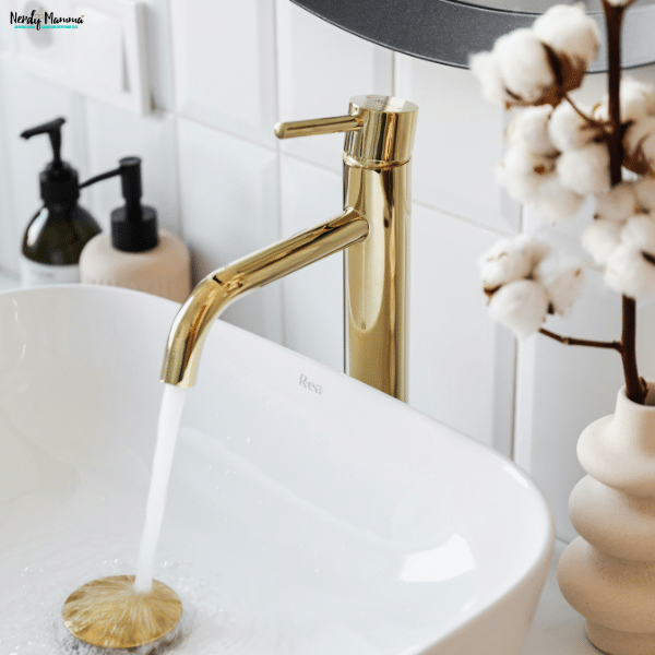 Modern vessel sink with a brushed gold faucet, showing how updated fixtures cna elevate bathroom style and functionality.