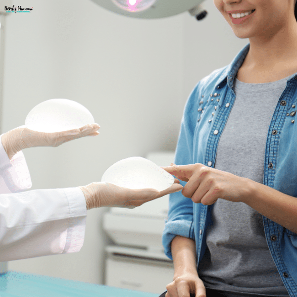 Woman consulting with a plastic surgeon while comparing breast implant options during a pre-surgery consultation.