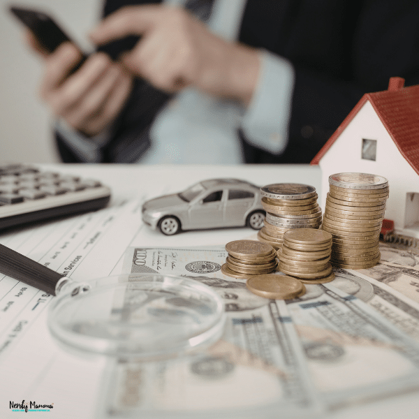 Coins, cash, and property-related assets arranged on financial documents, representing investment planning and long-term wealth management strategies.