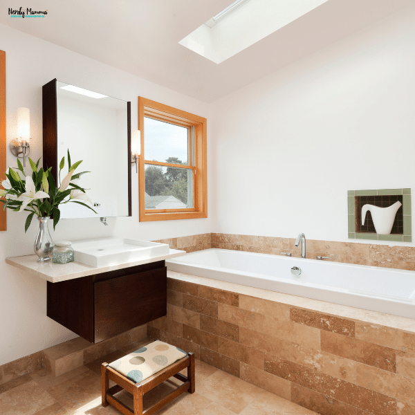 Modern bathroom with a floating vanity, soaking tub, skylight, and clean finishes, showcasing an updated space after a bathroom renovation.