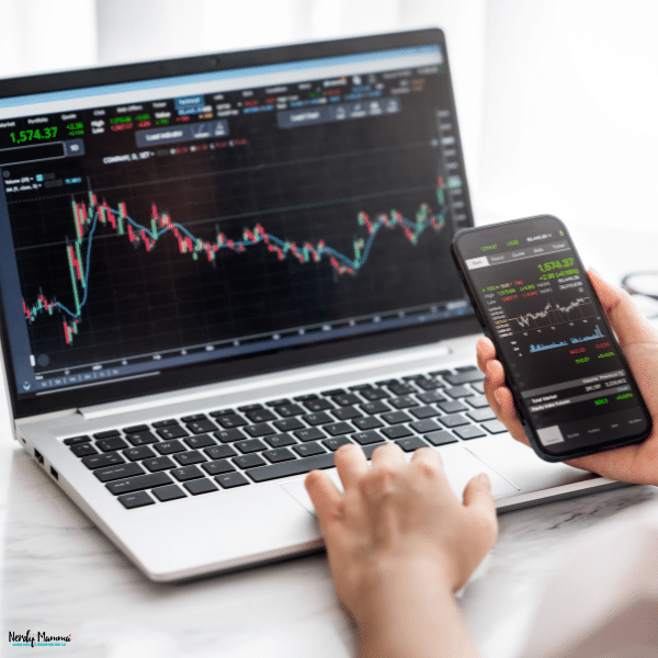 Trader monitoring financial market charts on a laptop and smartphone while using Eightcap for online trading and market analysis.