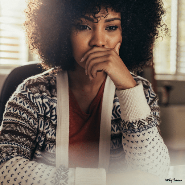 Person sitting thoughtfully indoors, representing the emotional process of rebuilding strength and confidence after a difficult life experience.