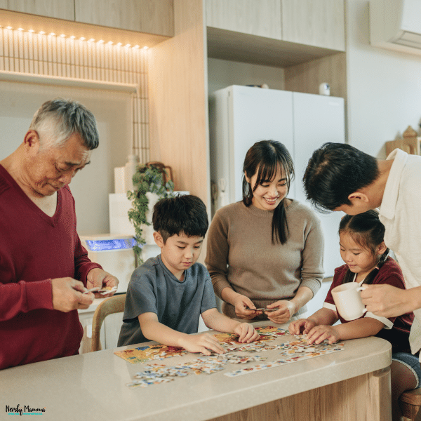 Family members of different generations working together on a jigsaw puzzle at the kitchen table during a fun indoor activity.