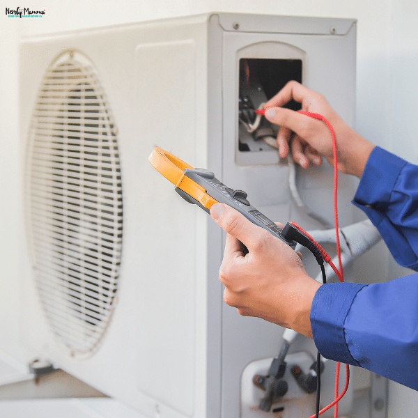Technician performing HVAC maintenance by testing electrical components to keep a commercial heating and cooling system operating efficiently.