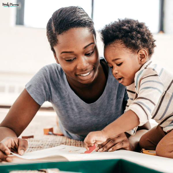 A parent helps a young child with a drawing activity, encouraging creativity, communication, and early childhood development.