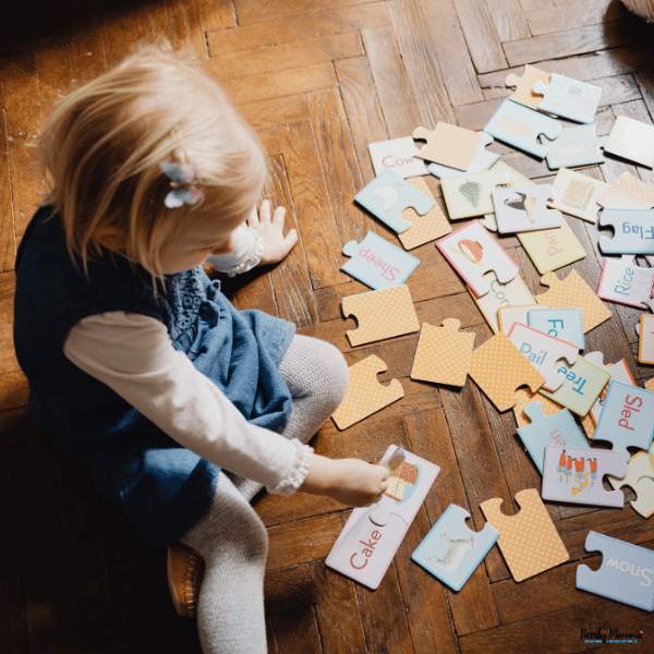 A young child matches colorful educational puzzle pieces on the floor to build problem-solving and cognitive skills through play.