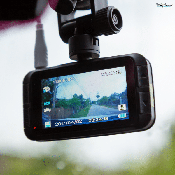 Windshield-mounted car dash cam recording the road ahead, demonstrating the benefits of continuous video coverage while driving.