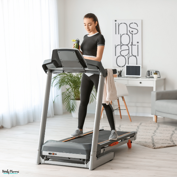 Person walking on a quiet home treadmill in a bright living space, showing a comfortable way to maintain a consistent indoor fitness routine.