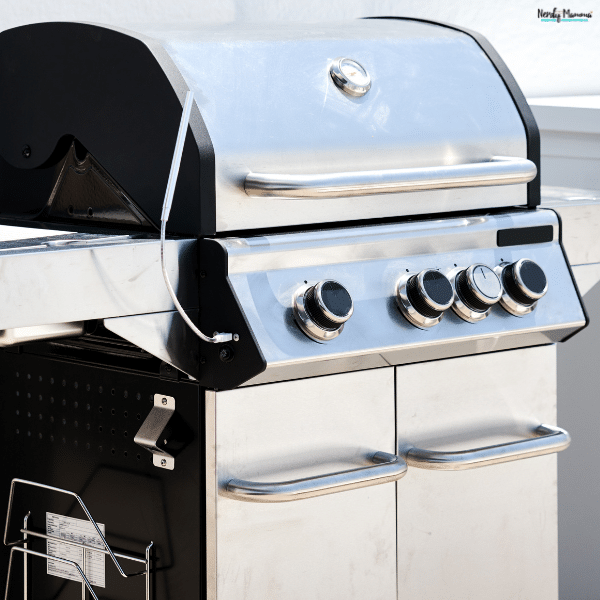 A stainless steel gas barbecue grill with multiple burners and a built-in temperature gauge, ready for outdoor cooking.