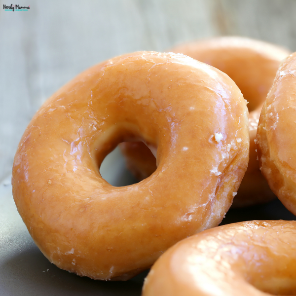 Fresh Amish glazed donuts with a soft, fluffy texture and glossy coating are arranged together on a serving plate.