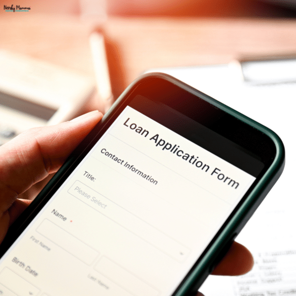 Person holding a smartphone with an online borrowing form, representing the process of applying for financing and planning responsible repayment.