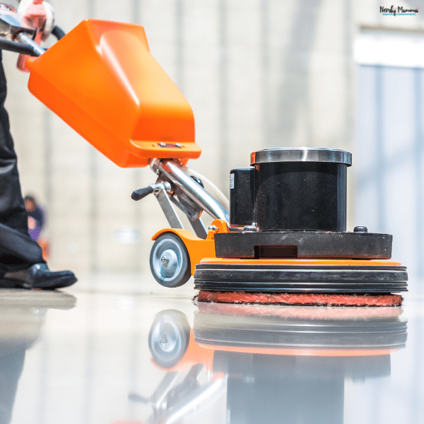 A commercial floor scrubber polishing a smooth hard floor, demonstrating efficient cleaning for large indoor spaces.