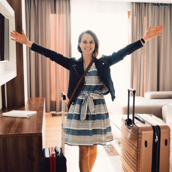 A traveler arrives at a hotel with luggage, representing an extended stay that may qualify for weekly hotel rates.