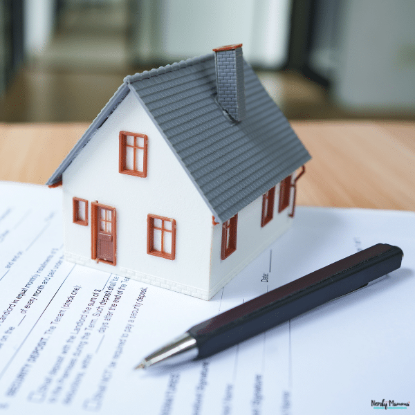 A model house and pen sit on paperwork, representing the leases and records involved in rental management.