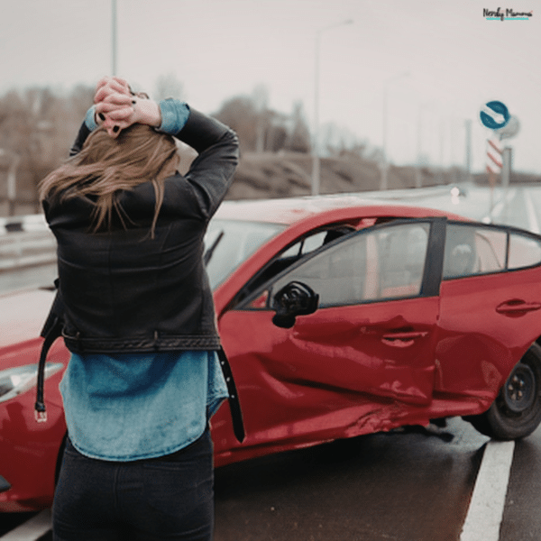 Woman standing beside a damaged car after a collision, showing an accident scene that may provide evidence when fault is contested.