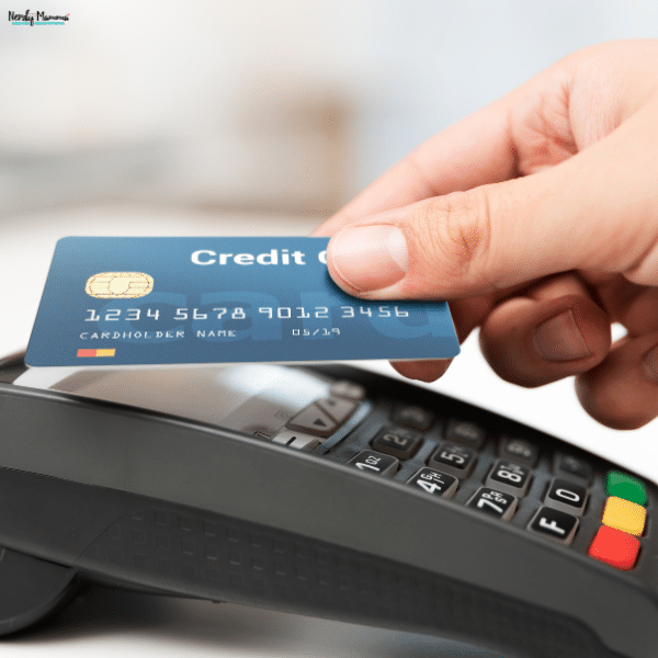 A hand holds a bank card above a payment terminal, showing a purchase made with borrowed funds.