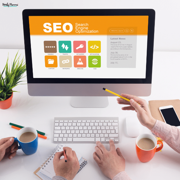 Colleagues review a desktop dashboard and take notes while planning an SEO engagement.