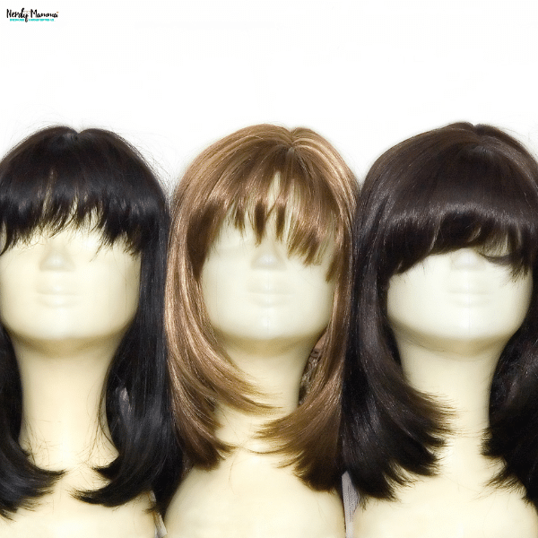 Three mannequin heads display dark and golden-brown wigs with bangs, showing hairstyle options for shoppers considering human hair lace front wigs.